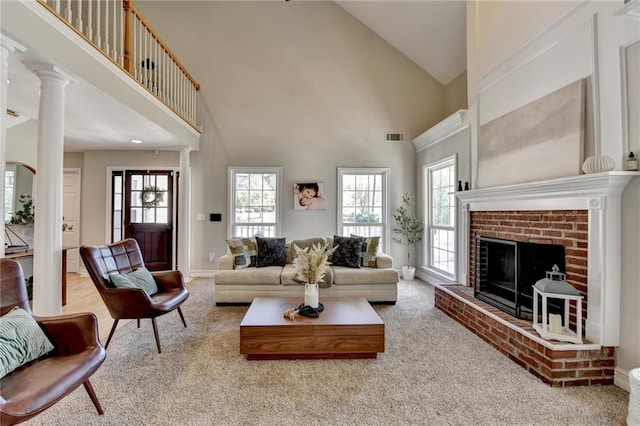 carpeted living area featuring visible vents, baseboards, high vaulted ceiling, and a fireplace
