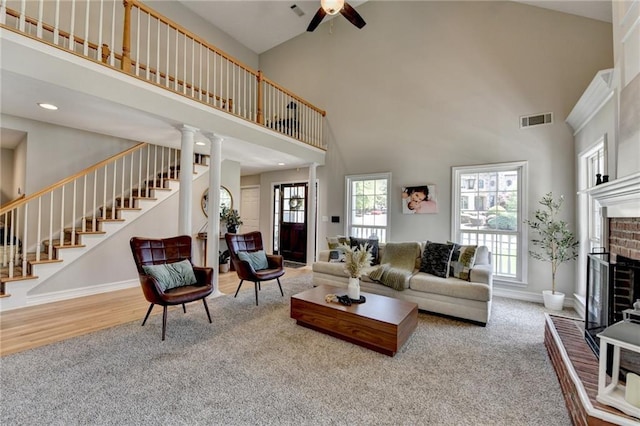living area with visible vents, high vaulted ceiling, stairway, and ceiling fan