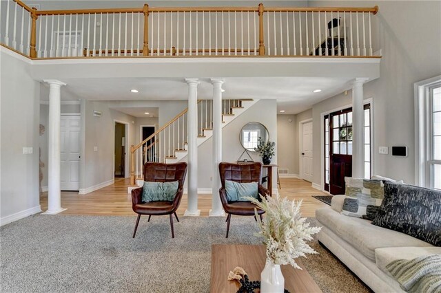 living room with baseboards, ornate columns, and a towering ceiling