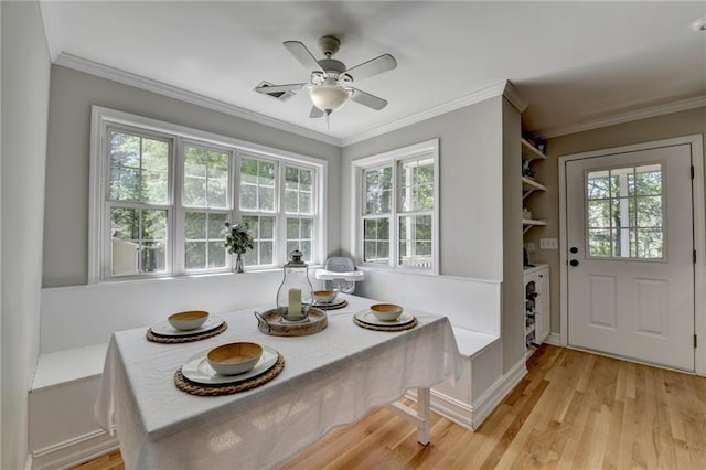 interior space featuring plenty of natural light, ornamental molding, and wood finished floors