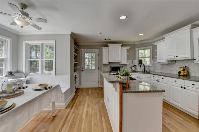 kitchen featuring white cabinets, a wealth of natural light, and light wood finished floors
