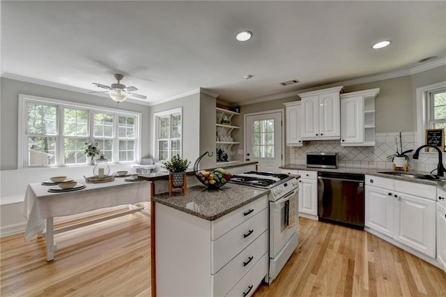 kitchen featuring open shelves, black dishwasher, gas range gas stove, visible vents, and a sink