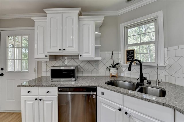 kitchen with stainless steel appliances, plenty of natural light, a sink, and light stone counters