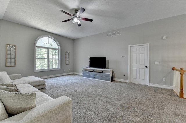 carpeted living room with baseboards, a textured ceiling, a ceiling fan, visible vents, and lofted ceiling