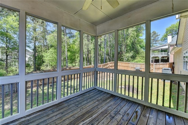 unfurnished sunroom featuring a ceiling fan and a healthy amount of sunlight