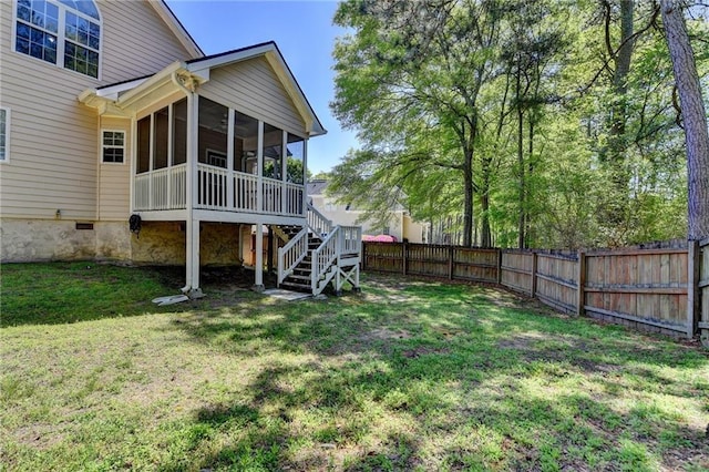 view of yard featuring a fenced backyard, stairway, and a sunroom