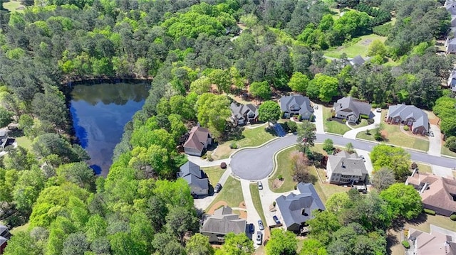 drone / aerial view featuring a water view, a residential view, and a view of trees