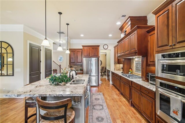 kitchen featuring visible vents, a sink, light wood-style flooring, and appliances with stainless steel finishes