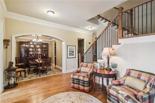 living room with arched walkways, stairway, a notable chandelier, and crown molding