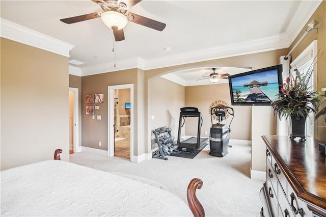 bedroom featuring baseboards, arched walkways, ceiling fan, crown molding, and light colored carpet