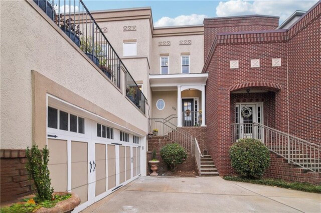 exterior space with a garage, driveway, and stucco siding