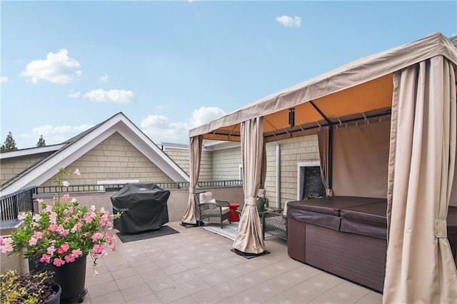 view of patio / terrace with a grill and a hot tub