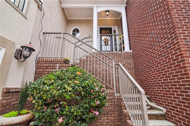 property entrance featuring brick siding and stucco siding