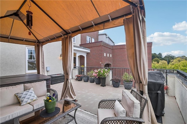 view of patio with a gazebo, a hot tub, and a balcony