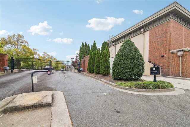 view of road with a gated entry, curbs, and a gate