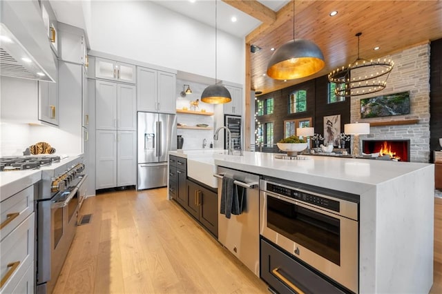 146 Overlook Way, Blue Ridge, GA 30513 - kitchen with high quality appliances, wall chimney exhaust hood, light wood-style flooring, light countertops, and a sink