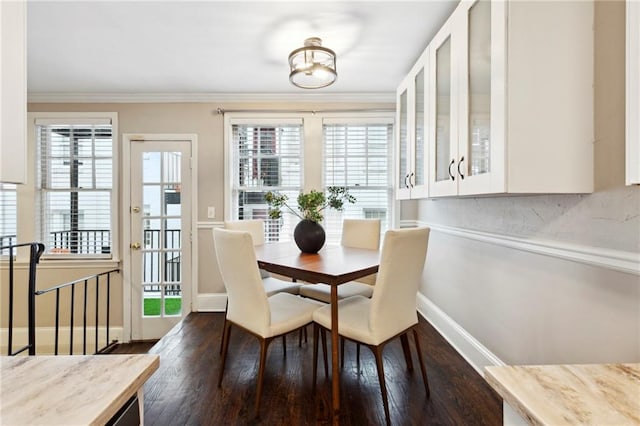 dining space with plenty of natural light, dark wood-type flooring, and crown molding