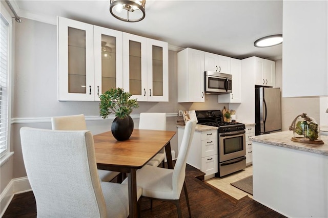 kitchen featuring light stone counters, white cabinets, stainless steel appliances, and dark hardwood / wood-style flooring