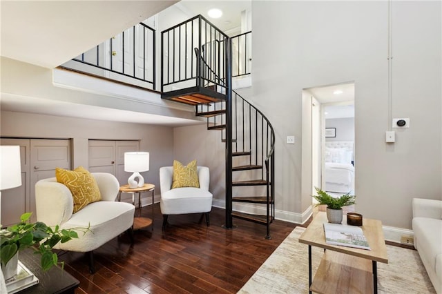 interior space featuring a towering ceiling and dark hardwood / wood-style floors