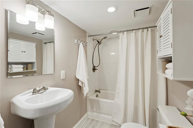 full bathroom with hardwood / wood-style flooring, sink, toilet, and shower / tub combo with curtain