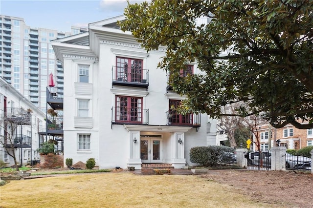 rear view of house with a yard and a balcony