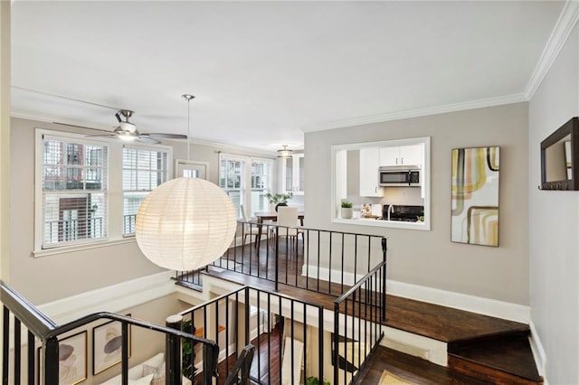 interior space with ceiling fan, ornamental molding, hardwood / wood-style flooring, and a healthy amount of sunlight