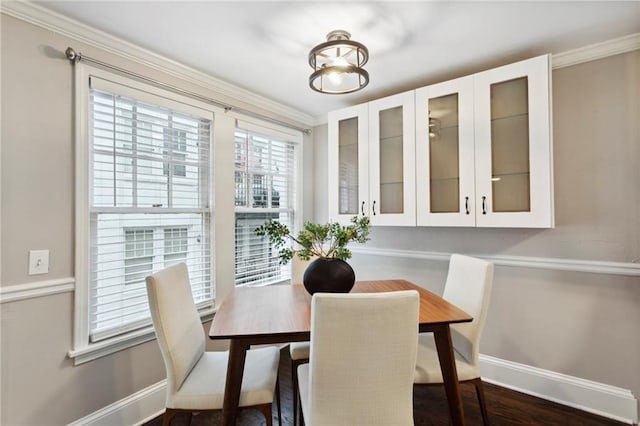 dining room with an inviting chandelier, dark wood-type flooring, and ornamental molding