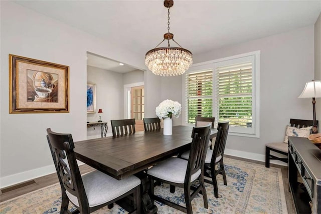 dining area featuring hardwood / wood-style floors and a chandelier