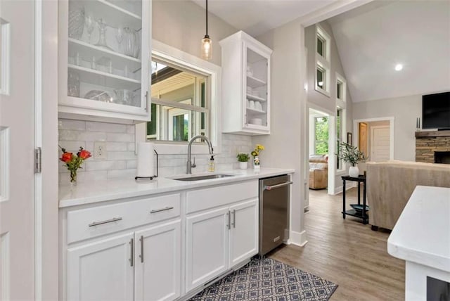 kitchen with stainless steel dishwasher, sink, hanging light fixtures, and white cabinets