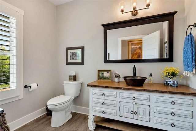 bathroom featuring wood-type flooring, vanity, and toilet