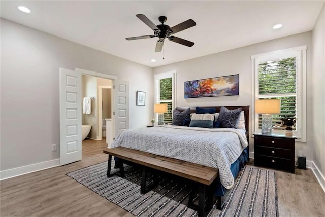 bedroom with connected bathroom, hardwood / wood-style floors, and ceiling fan