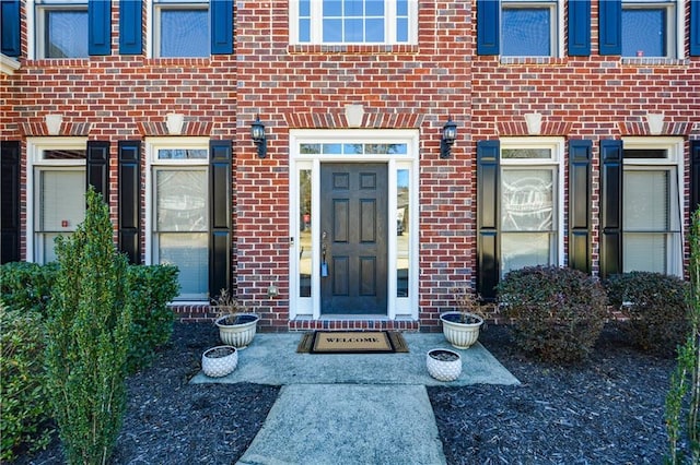 entrance to property featuring brick siding