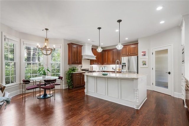 kitchen featuring baseboards, dark wood-style flooring, custom exhaust hood, and stainless steel fridge with ice dispenser