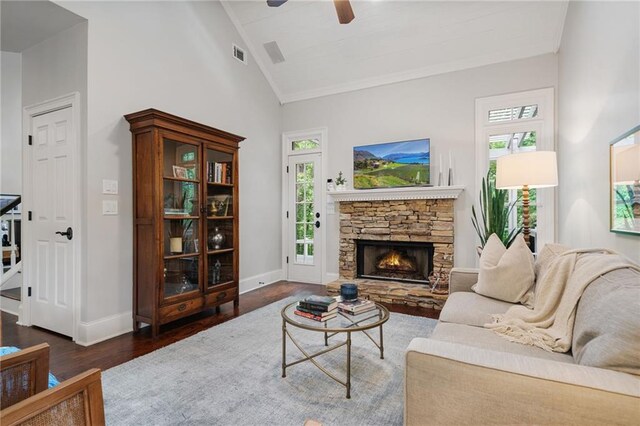 living room with visible vents, wood finished floors, a wealth of natural light, a ceiling fan, and vaulted ceiling