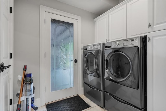 washroom featuring light tile patterned floors, separate washer and dryer, and cabinet space