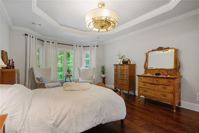 bedroom with crown molding, a chandelier, wood finished floors, a tray ceiling, and visible vents