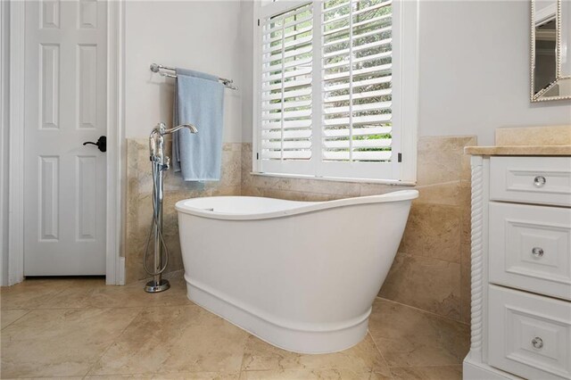 ensuite bathroom with crown molding, vanity, baseboards, wood finished floors, and ensuite bathroom