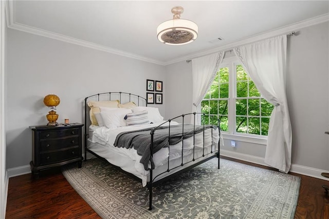bedroom with baseboards, ornamental molding, and wood finished floors