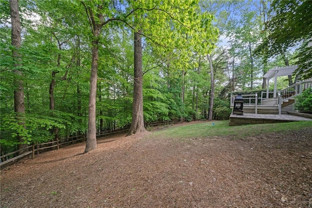 view of yard featuring a pergola, fence, and a wooden deck