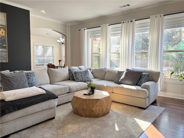 living room with crown molding, wood-type flooring, and a chandelier