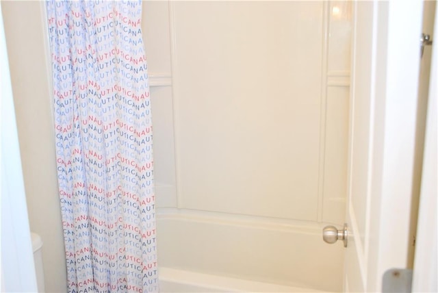 bathroom featuring shower / tub combo with curtain and toilet