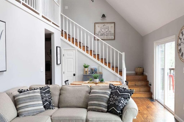 living room with high vaulted ceiling and wood-type flooring