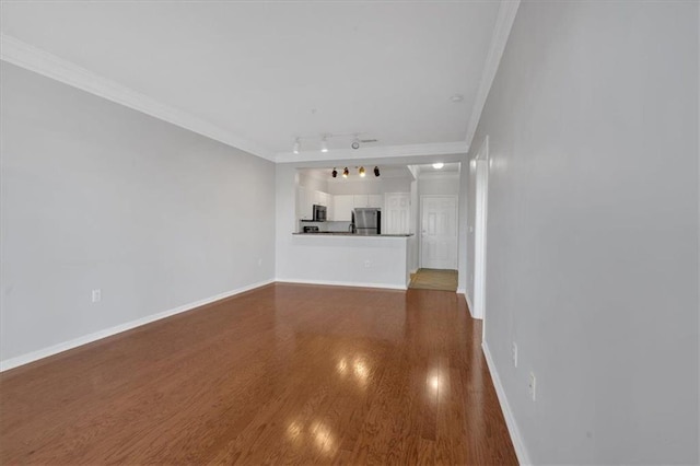 unfurnished living room with track lighting, crown molding, and wood-type flooring