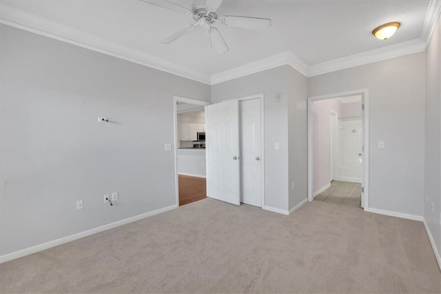 unfurnished bedroom featuring ceiling fan, ornamental molding, a closet, and light colored carpet