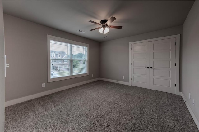 unfurnished bedroom featuring carpet flooring, ceiling fan, and a closet