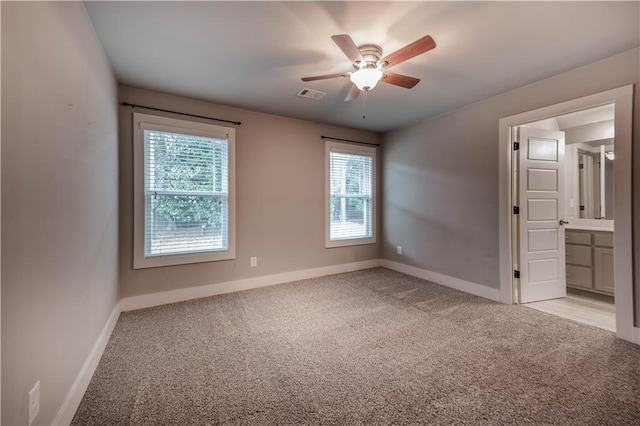 carpeted spare room with ceiling fan