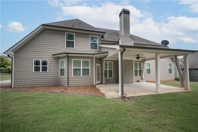 rear view of property featuring ceiling fan, a yard, and a patio