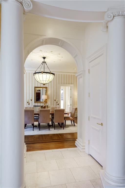 hallway featuring crown molding and decorative columns