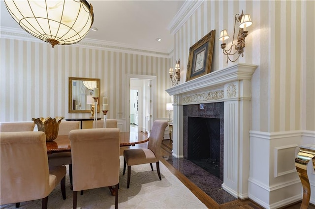 dining space featuring crown molding and a premium fireplace