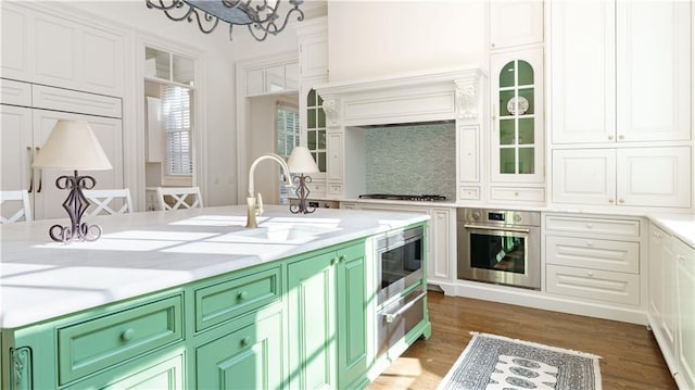 kitchen featuring appliances with stainless steel finishes, dark hardwood / wood-style floors, white cabinetry, sink, and green cabinetry